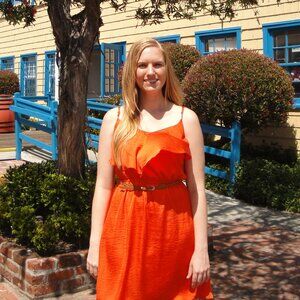 Bright orange ruffled dress with belt.